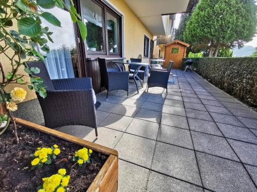 a patio with chairs and a table and flowers at Zur schönen Aussicht in Schotten