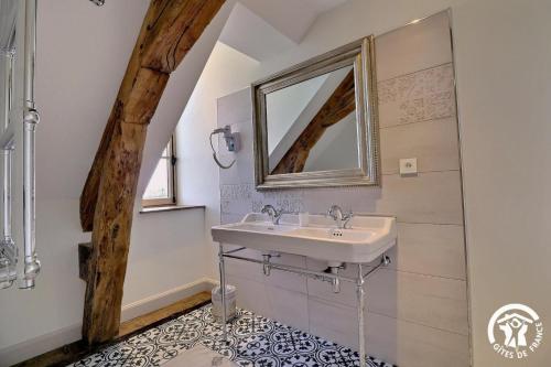 ein Bad mit einem Waschbecken und einem Spiegel in der Unterkunft Chateau de la giraudais in Mézières-sur-Couesnon