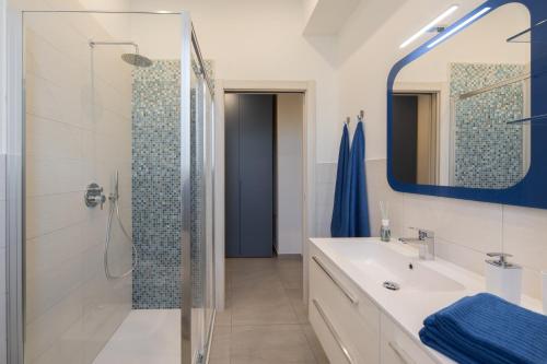 La salle de bains est pourvue d'une douche, d'un lavabo et d'un miroir. dans l'établissement Lucy’s House, à Cologno Monzese