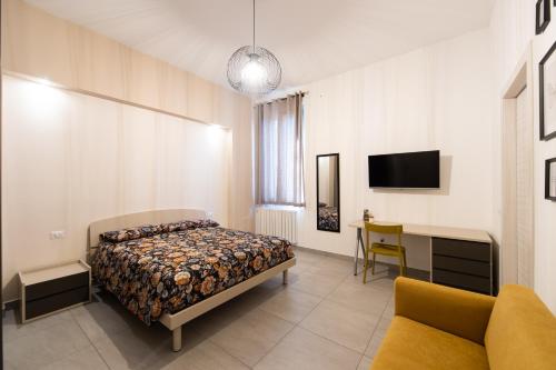 - une chambre avec un lit, un bureau et une télévision dans l'établissement Lucy’s House, à Cologno Monzese