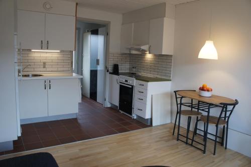 eine Küche mit weißen Schränken sowie einem Tisch und Stühlen in der Unterkunft (id110) Grønlandsparken 56. G in Esbjerg