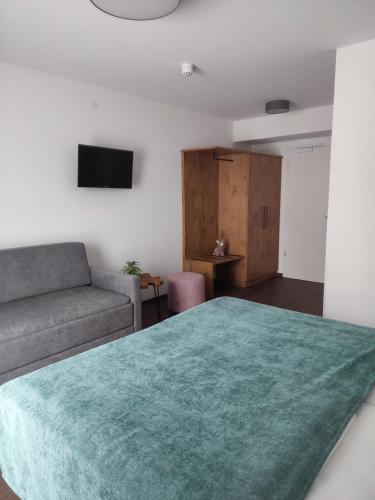 a living room with a bed and a couch at Hotel & Appartements Nice Garni in Ichenhausen