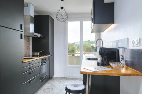 a kitchen with stainless steel appliances and a counter top at L'Émeraude, T3 élégant avec vue proche Centre et gare in Vienne