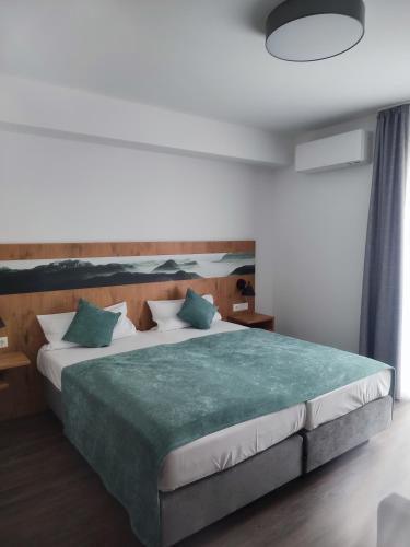 a bedroom with a large bed with a green blanket at Hotel Nice garni in Ichenhausen