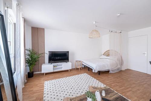 a white room with a bed and a television at New Studio Disneyland en 10 min Paris 30 min in Montévrain