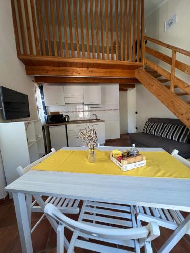 a dining room table with a yellow table cloth on it at Da Ale e De in Isolabona