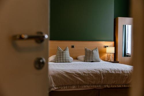 a bedroom with a bed with two pillows on it at Hotel Malleberg in Bruges