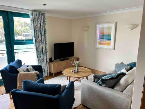 a living room with two couches and a television at Crabshell Quay waterfront living in Kingsbridge in Kingsbridge