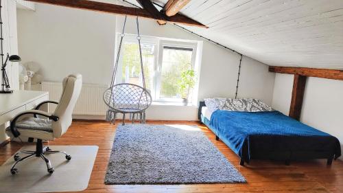 a bedroom with a swing bed and a chair at Seeyouin Karmelicka18 Apartment in Krakow
