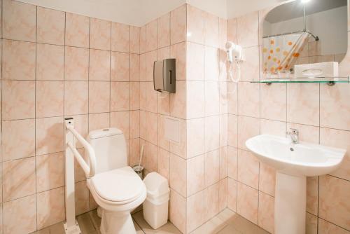 a bathroom with a toilet and a sink at Dinaburg SPA Hotel in Daugavpils