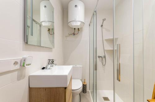 uma casa de banho com um WC, um lavatório e um chuveiro em YourHouse Monges apartment with balcony em Can Picafort