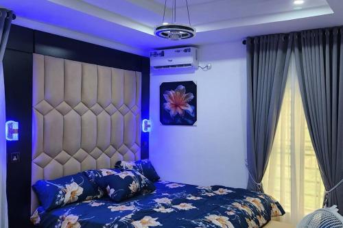 1 dormitorio con 1 cama grande con iluminación azul en MeTime Residence Enugu, en Enugu