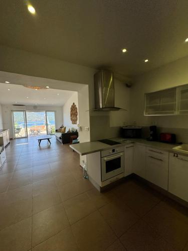 a kitchen with white appliances and a living room at Appartement face à la mer 4 pers in Propriano