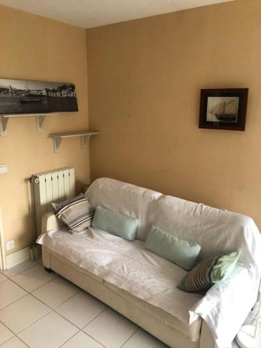 - un canapé blanc dans le salon avec des oreillers dans l'établissement Appartement de 27 m carré à ciboure avec terrasse, à Ciboure