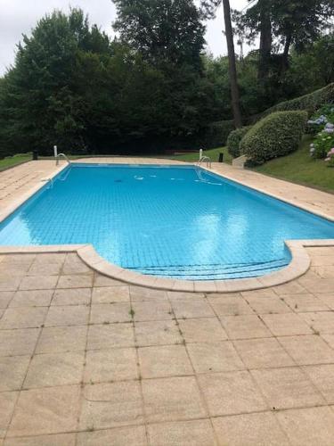 une grande piscine bleue dans une cour dans l'établissement Appartement de 27 m carré à ciboure avec terrasse, à Ciboure