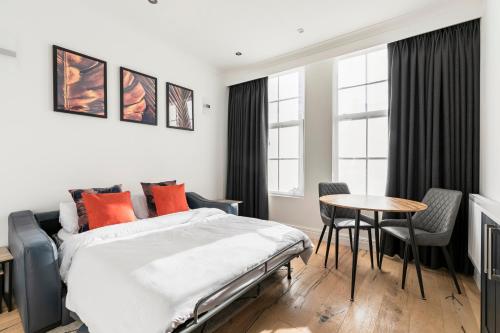 1 dormitorio con 1 cama, mesa y sillas en Modern Apartment, 2 Stops to Central London, Netflix, Smart Locks, en Ealing