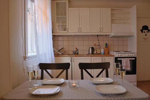 een keuken met een tafel met borden en wijnglazen bij Lagertha’s apartment,downtown Reykjavik in Reykjavík
