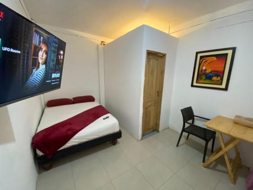 ein Schlafzimmer mit einem Bett und einem TV an der Wand in der Unterkunft UFO Rooms in Montañita