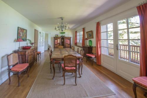 une salle à manger avec une table et des chaises en bois dans l'établissement Lac d'Annecy Villa Pieds dans l'eau, à Sévrier