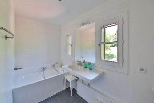 Un baño blanco con lavabo y bañera. en Lac d'Annecy Villa Pieds dans l'eau, en Sévrier