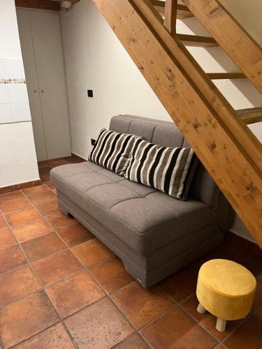 a couch sitting in a living room under a staircase at Da Ale e De in Isolabona