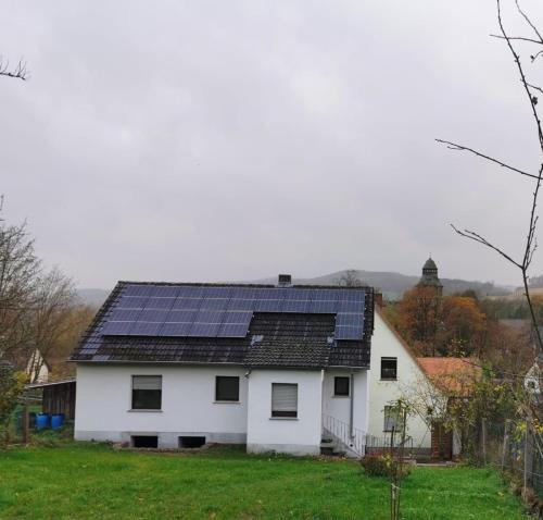 ein weißes Haus mit Sonnenkollektoren auf dem Dach in der Unterkunft Ferienhaus Lichtenberg - b46149 in Herleshausen