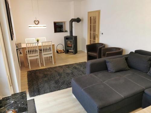 ein Wohnzimmer mit einem Sofa und einem Holzofen in der Unterkunft Ferienhaus Lichtenberg - b46149 in Herleshausen