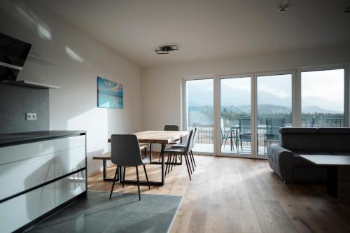 - une cuisine et une salle à manger avec une table et des chaises dans l'établissement Premium Apartments Monterra, à Petschnitzen