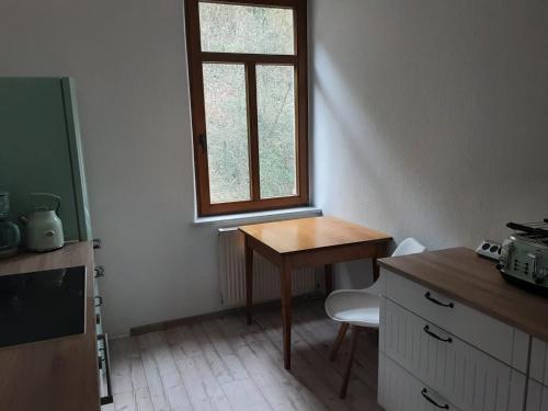 einen kleinen Tisch und ein Fenster in einem Zimmer in der Unterkunft Ferienwohnung mit Blick auf die Elbe und den Lilienstein in Königstein an der Elbe