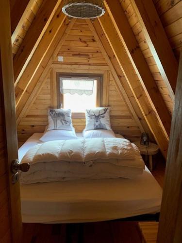 a bed in a room with a window at Chalet 8 à 10 couchages in Le Dévoluy