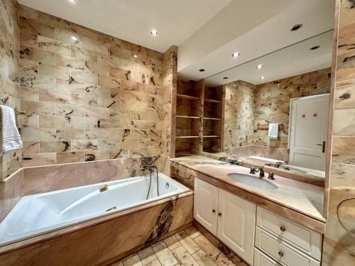 ein Badezimmer mit einer Badewanne und einem Waschbecken in der Unterkunft Cannes Croisette - Appartement 5 pièces face mer in Cannes