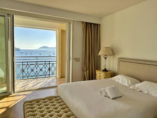 Schlafzimmer mit einem Bett und Meerblick in der Unterkunft Cannes Croisette - Appartement 5 pièces face mer in Cannes