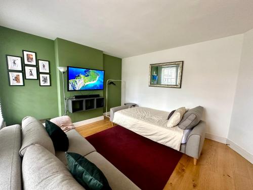 a living room with a couch and a flat screen tv at Colindale Lush Stay 30 mins central London in Colindale