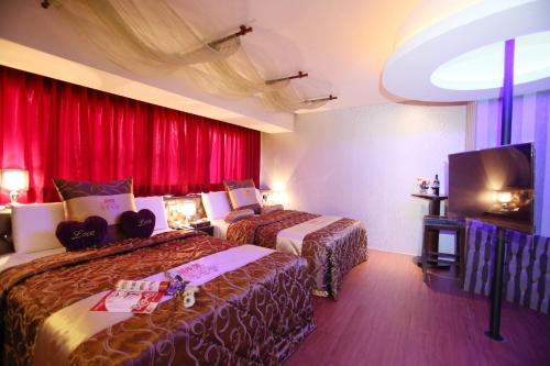 a hotel room with two beds and a flat screen tv at Wsb Motel-Rende in Tainan