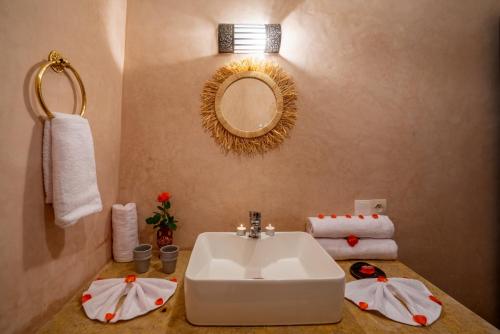 a bathroom with a sink and a mirror and towels at BÔ Riad Boutique Hotel & Spa in Marrakech