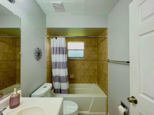 ein Badezimmer mit einer Badewanne, einem WC und einem Waschbecken in der Unterkunft Fort Myers Beach Escape 3 Miles Away Sleep 7 in Fort Myers Beach