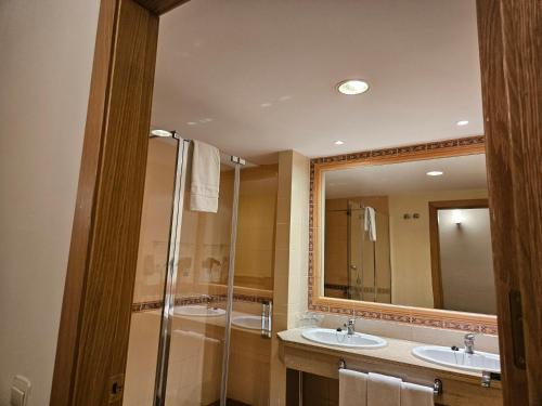 a bathroom with two sinks and a shower at Hotel Telecabina in Sierra Nevada