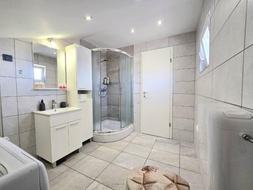uma casa de banho com um chuveiro, um WC e um lavatório. em Apartmani Krnić em Sibenik