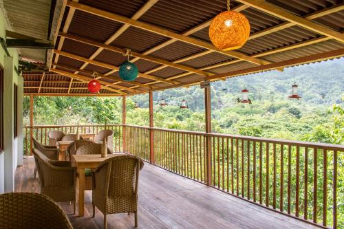 a porch with a table and chairs and a view of the mountains at Hotel Minca - La Casona in Minca