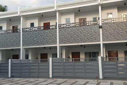 a large white building with a fence in front of it at Kings' Palms Residence02 in General Santos