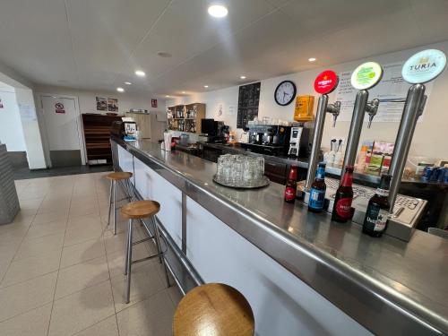 a bar in a restaurant with two stools at Camping Bungalow el Llac de Banyoles in Porqueres