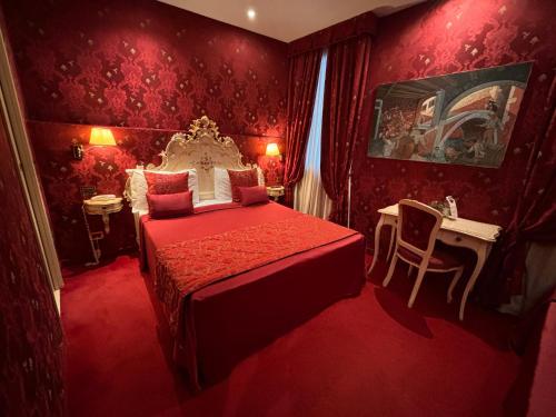 a bedroom with a red room with a bed and a desk at Hotel al Graspo de Ua in Venice