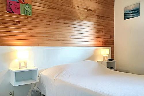 a bedroom with a white bed and two lamps at Maison charmante à Vielle-Saint-Girons avec vue sur le lac. in Vielle-Saint-Girons