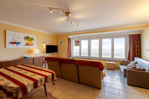 Un dormitorio con una cama y un sofá y una ventana. en Calvi 0602 G, en Koksijde