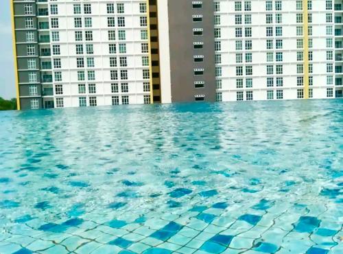 a swimming pool in front of tall buildings at Mesahill 2 Bedroom by DKAY in Nilai in Nilai