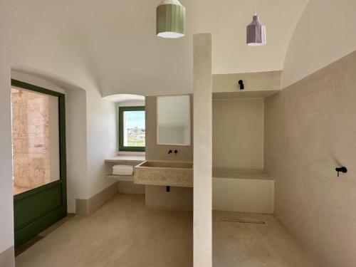 uma casa de banho com um lavatório e uma janela em Masseria Valentina em Ostuni