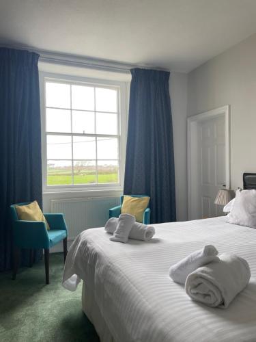 a bedroom with a large bed with towels on it at Trevanger Farm Bed and Breakfast in Wadebridge