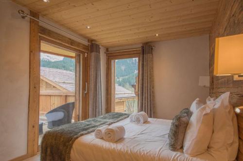 una camera da letto con un letto e una grande finestra di Savoielac - La Clusaz- Piscine intérieure : Chalet Viking a La Clusaz
