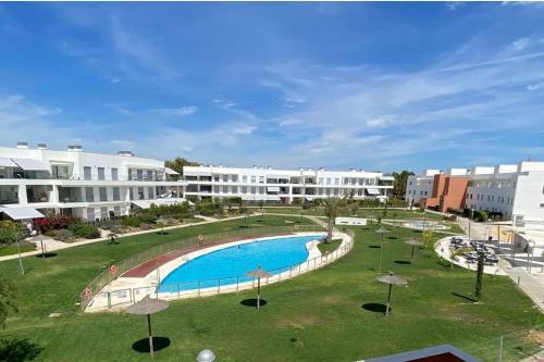 a swimming pool in a park with white buildings at Duplex penthouse close to the beach in Costa Ballena