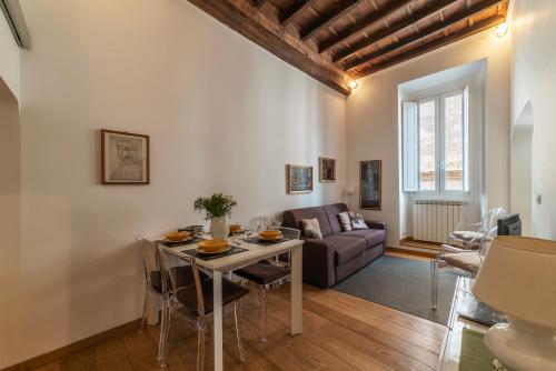 a living room with a table and a couch at Con il Pantheon fuori dalla finestra - FromHometoRome in Rome